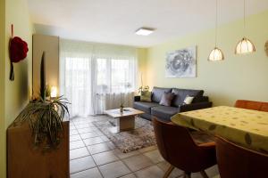 ein Wohnzimmer mit einem Sofa und einem Tisch in der Unterkunft Ado Ferienwohnung in Grafenhausen