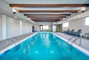 a swimming pool with blue water in a building at Home2 Suites By Hilton Whitestown Indianapolis Nw in Whitestown