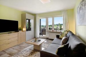 een woonkamer met een bank en een flatscreen-tv bij Ado Ferienwohnung in Grafenhausen