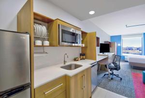 a kitchen with a sink and a refrigerator at Home2 Suites By Hilton Whitestown Indianapolis Nw in Whitestown
