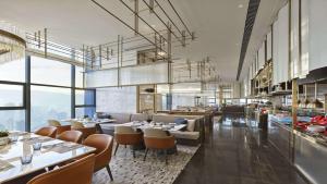 a dining room with tables and chairs and windows at Hilton Lanzhou City Center in Lanzhou