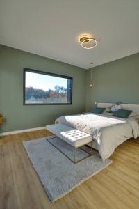 um quarto com uma cama grande e uma janela em Villa haut de gamme dans un parc de verdure em Tournefeuille