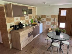 a kitchen with a table and a sink and a counter at HuniHáz Apartman in Sovata