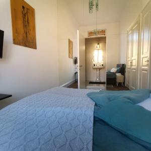 ein Schlafzimmer mit einem blauen Bett und ein Wohnzimmer in der Unterkunft philip mansion in Ljubljana
