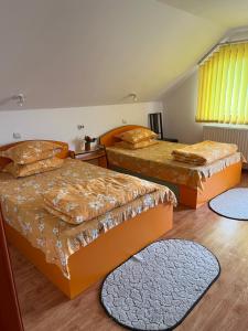 a bedroom with two beds and two rugs at HuniHáz Apartman in Sovata