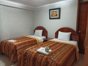 een hotelkamer met 2 bedden en handdoeken erop bij Mallmanya Inn in Cuzco