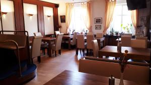 a dining room with tables and chairs and windows at Hotel Krone Lindow in Lindow