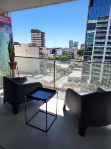 un balcone con 2 divani, un tavolo e una grande finestra di Departamento increíble en Av. Libertador, Belgrano a Buenos Aires