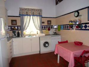 uma cozinha com um lavatório e uma máquina de lavar roupa em Casa no Campo T3 e Piscina de PortusAlacer em Portalegre
