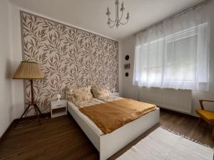 um quarto com uma cama e uma parede em AranyLak vendégház em Abádszalók