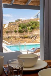 a table with a bowl and a view of a pool at Terra White Seaview Pool Apartments & Suites in Mikonos