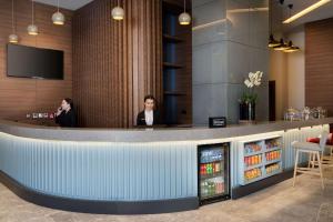 two people sitting at a bar in a restaurant at Hampton By Hilton Tashkent in Tashkent