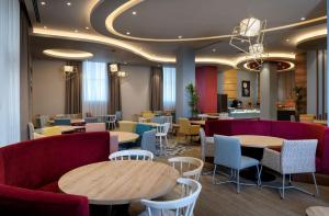 um restaurante com sofás, mesas e cadeiras em Hampton By Hilton Tashkent em Tashkent