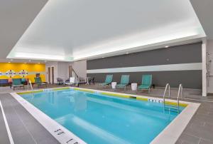 a pool in a hotel room with chairs around it at Tru By Hilton Ashburn One Loudoun, Va in Ashburn