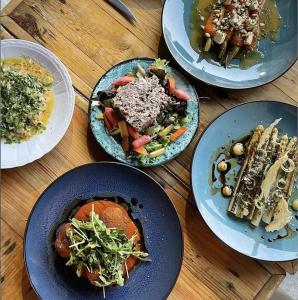 a group of plates of food on a wooden table at La Cour Verte Chambres d'Hôtes in Montépilloy