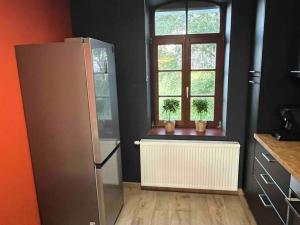 a kitchen with a refrigerator and a window at Appartement situé dans la nature des Hautes-Fagnes in Waimes