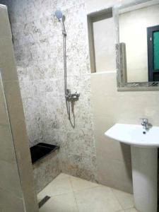 ein Bad mit einer Dusche und einem Waschbecken in der Unterkunft Family Beach Saïdia in Saidia 