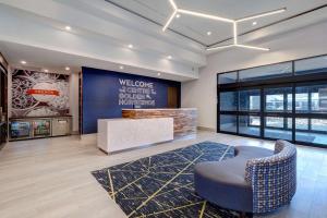 a lobby with a waiting area with a chair and a sign at Hampton Inn & Suites Burlington, Ontario, Canada in Burlington