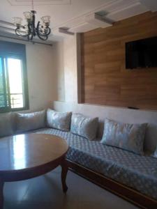 ein Wohnzimmer mit einem Sofa und einem Tisch in der Unterkunft Family Beach Saïdia in Saidia 