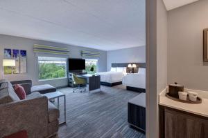 Habitación de hotel con cama y sala de estar. en Hampton Inn & Suites Burlington, Ontario, Canada en Burlington