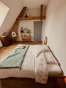 1 dormitorio con 1 cama grande en el ático en La Cour Verte Chambres d'Hôtes, en Montépilloy