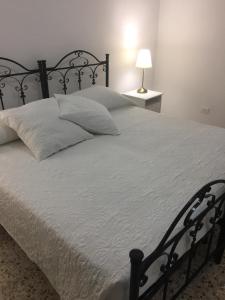 1 cama grande con marco negro y sábanas blancas en Villino Donna Rita, en Lecce