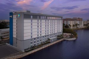 un gran edificio blanco junto a una masa de agua en Tru By Hilton Miami Airport South Blue Lagoon, Fl, en Miami