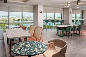 um restaurante com mesas, cadeiras e janelas em Tru By Hilton Miami Airport South Blue Lagoon, Fl em Miami