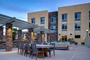 蒂梅丘拉Hilton Garden Inn Temecula的一个带桌椅的庭院和一座建筑