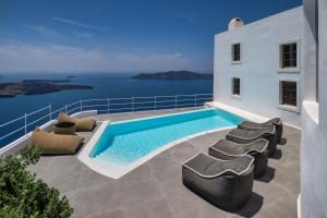 a villa with a swimming pool on a balcony at Eteoro Suites in Imerovigli
