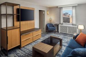 ein Hotelzimmer mit einem TV und einem Wohnzimmer in der Unterkunft DoubleTree by Hilton Silver Spring Washington DC North in Silver Spring