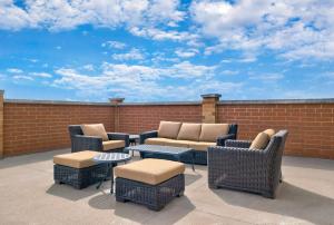 a patio with chairs and tables and a brick wall at DoubleTree by Hilton Davenport in Davenport