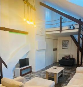 - un salon avec un escalier, un canapé et une table dans l'établissement JÓKAI Apartman, à Komárno