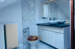 a white bathroom with a toilet and a sink at JÓKAI Apartman in Komárno