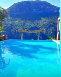 una piscina de agua azul con una montaña en el fondo en DDG Retreat, en Casares