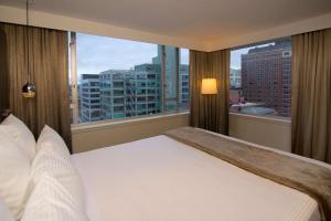 a bedroom with a large bed with a view of a city at The Benson Portland, Curio Collection by Hilton in Portland