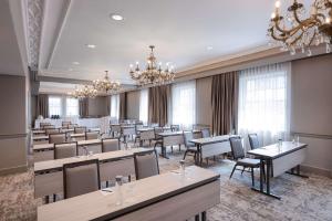 a dining room with tables and chairs and a chandelier at The Benson Portland, Curio Collection by Hilton in Portland