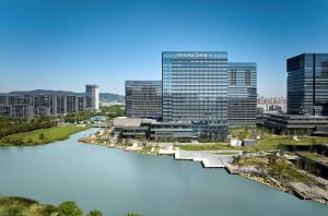 苏州苏州吴中希尔顿逸林酒店的有河流和建筑物的城市景观