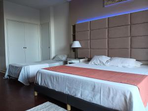 a bedroom with two beds and a large headboard at Estoril Beach in Estoril
