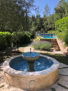a fountain in the middle of a garden at Villa piscine 30 minutes de Nice in Le Broc