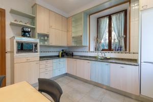 a kitchen with white cabinets and a table and a window at Villa Ganbara in Villava