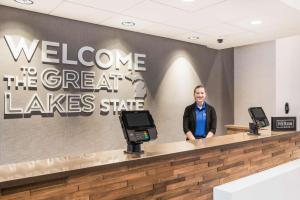 a man standing at a welcome to the great lakes state sign at Hampton Inn & Suites Houghton in Houghton