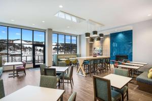 a restaurant with tables and chairs and a fireplace at Hampton Inn & Suites Houghton in Houghton