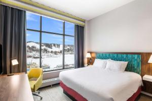 a hotel room with a bed and a large window at Hampton Inn & Suites Houghton in Houghton