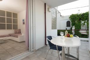 a white table with a bowl of fruit on a balcony at Markakis Apartments in Elounda