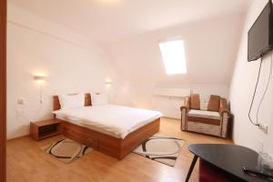 1 dormitorio pequeño con 1 cama y 1 silla en Pensiunea Cavaler, en Băile Felix