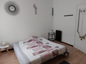 ein Schlafzimmer mit einem Bett und einer Uhr an der Wand in der Unterkunft Chambre près de l'étang de thau in Mèze