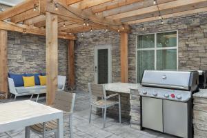 un patio con parrilla, mesa y sillas en Homewood Suites By Hilton Mcdonough en McDonough