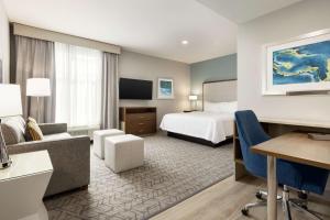 Habitación de hotel con cama y escritorio en Homewood Suites By Hilton Mcdonough en McDonough
