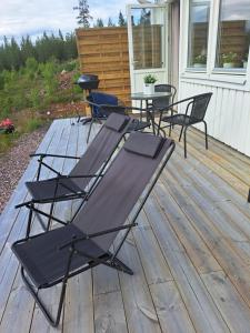 a deck with chairs and a table on it at Mysig lägenhet med fjällutsikt i Sälen in Sälen